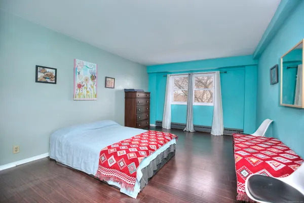 a bedroom with a bed and a lamp on dresser