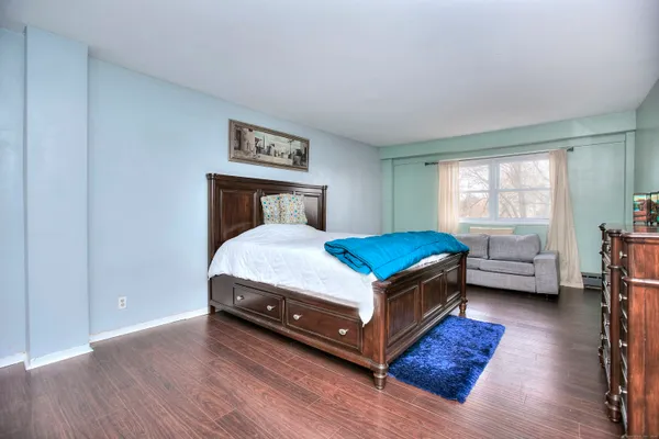 a bed sitting in a spacious bedroom next to a window