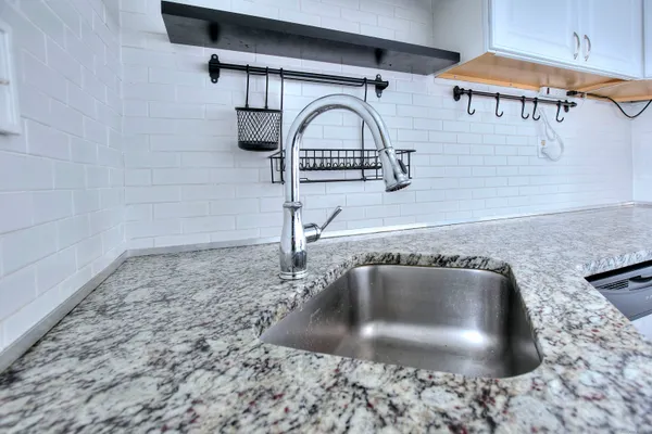 a kitchen with stainless steel appliances granite countertop a sink a stove a microwave and cabinets