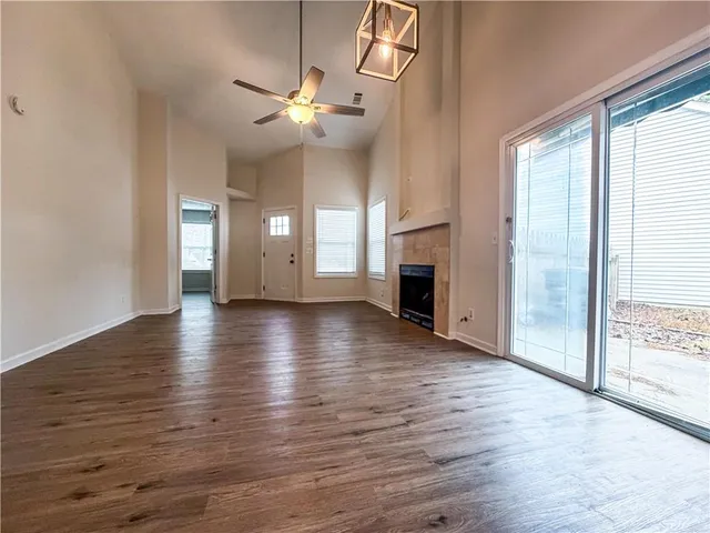 an empty room with wooden floor fireplace and a window
