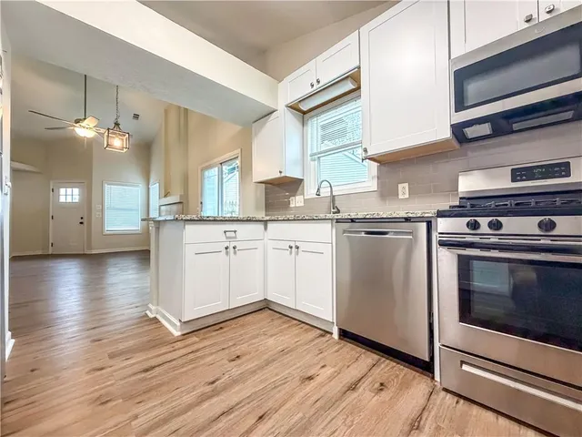 a kitchen with white cabinets and refrigerator