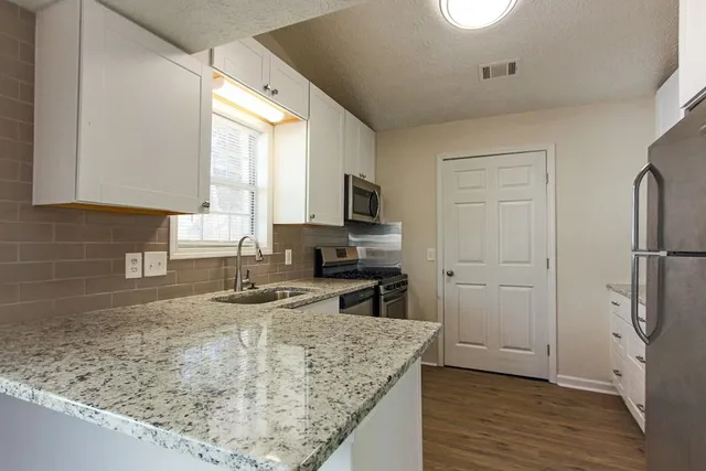 a kitchen with stainless steel appliances granite countertop a sink and a stove