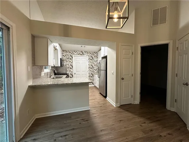 a view of an empty room with wooden floor fireplace and a window
