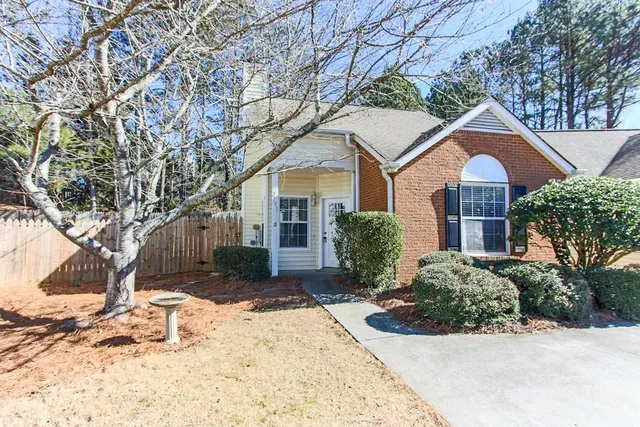a front view of a house with a yard covered in snow