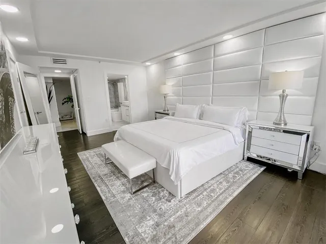 a bedroom with a bed wooden floor and a mirror
