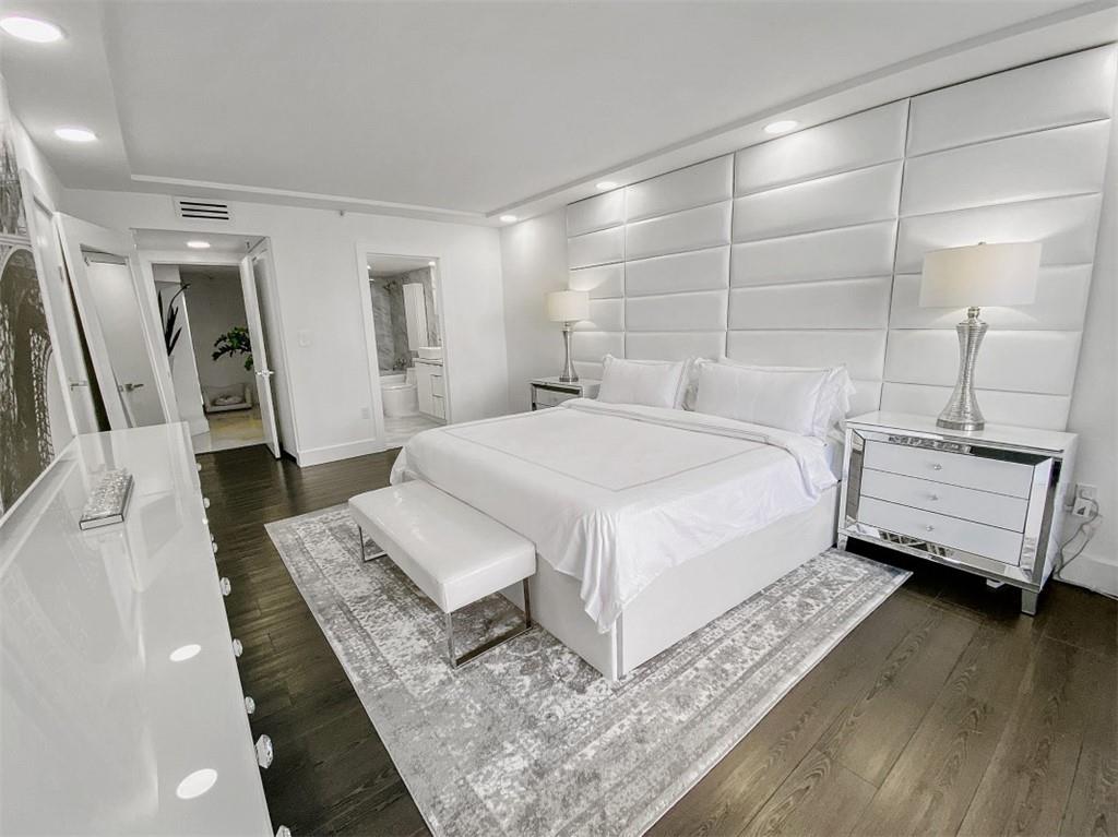 555 Northeast 15th Street, Unit 32C Miami, FL 33132 - Photo 11 of 21 a bedroom with a bed wooden floor and a mirror