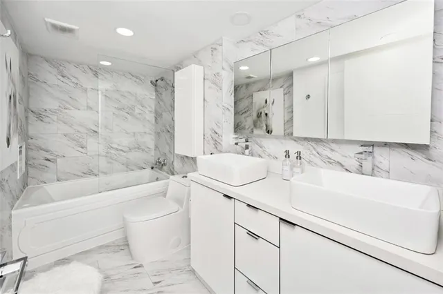 a bathroom with a sink toilet vanity and bathtub