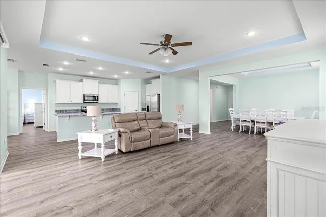 a spacious bedroom with a large bed a chandelier and dresser