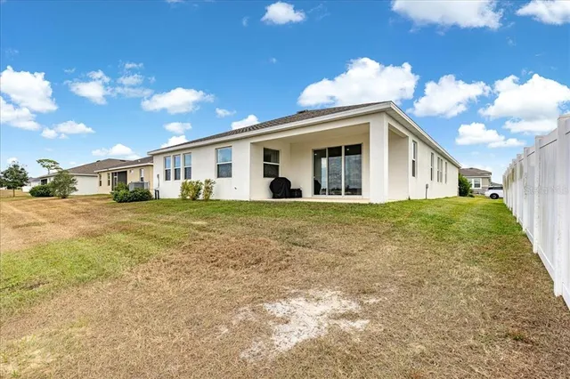 a view of a white house with a big yard and a fountain