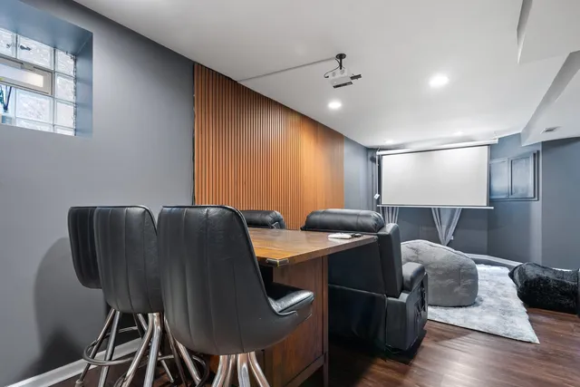a media room with lots of chairs and wooden floor