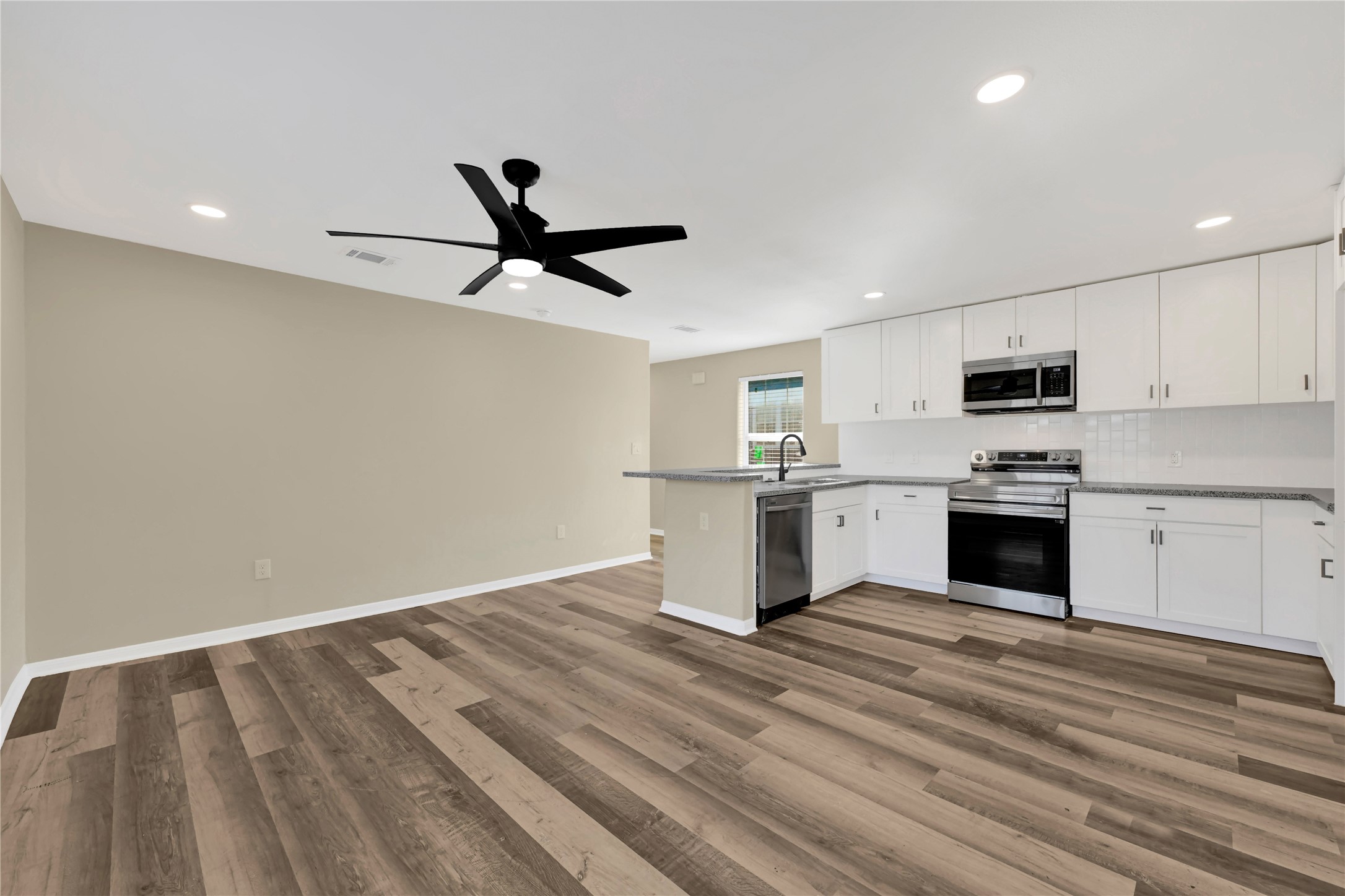 7814 Avenue F Houston, TX 77012 - Photo 12 of 28 a kitchen with a refrigerator and white cabinets