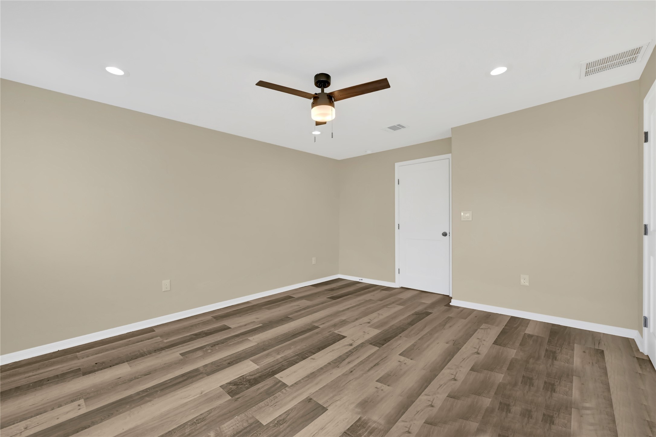 7814 Avenue F Houston, TX 77012 - Photo 21 of 28 an empty room with a ceiling fan and wooden floor