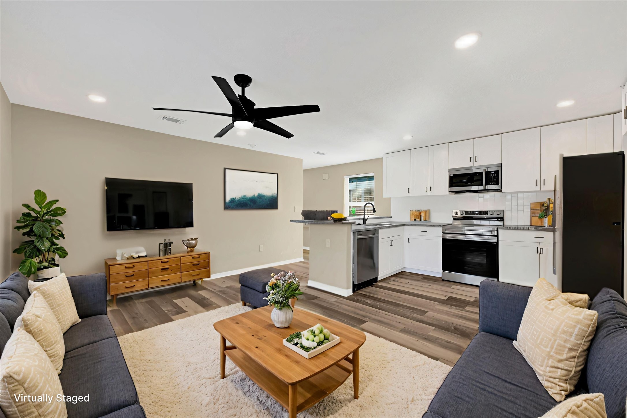 7814 Avenue F Houston, TX 77012 - Photo 3 of 28 a living room with furniture and a flat screen tv with kitchen view