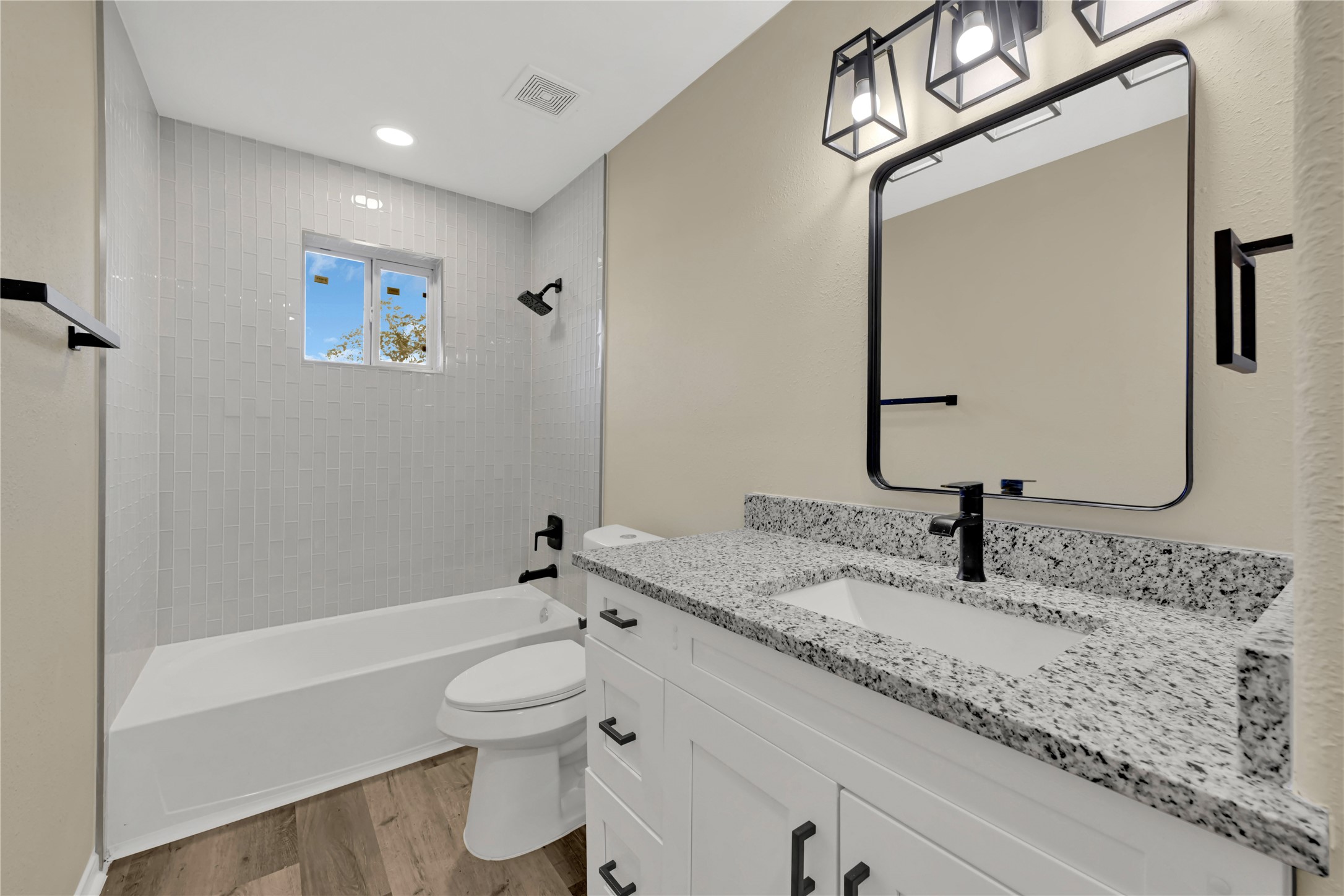 7814 Avenue F Houston, TX 77012 - Photo 6 of 28 a bathroom with a granite countertop sink a toilet and a bathtub