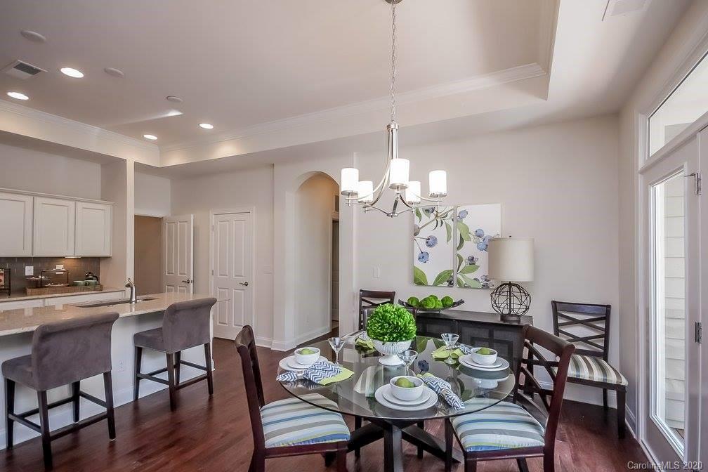 2018 New Style Way, Unit 5 Tega Cay, SC 29708 - Photo 17 of 36 a view of a dining room with furniture a chandelier and wooden floor