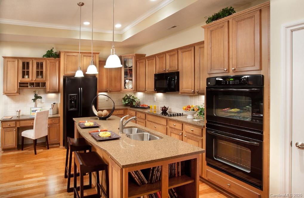 2018 New Style Way, Unit 5 Tega Cay, SC 29708 - Photo 24 of 36 a kitchen with a table chairs microwave and refrigerator