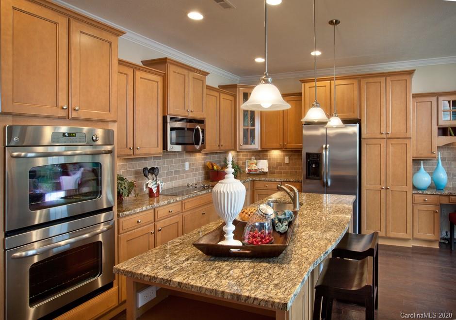 2018 New Style Way, Unit 5 Tega Cay, SC 29708 - Photo 25 of 36 a kitchen with stainless steel appliances granite countertop a stove refrigerator and cabinets
