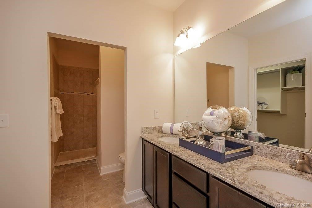 2018 New Style Way, Unit 5 Tega Cay, SC 29708 - Photo 30 of 36 a bathroom with a granite countertop sink and a mirror