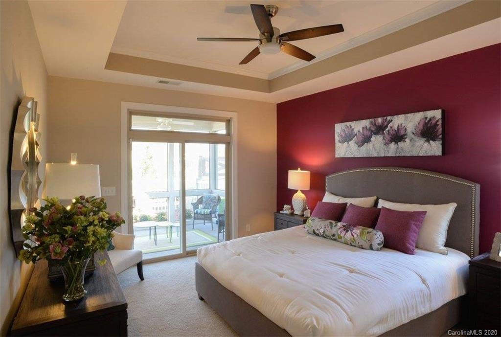 2018 New Style Way, Unit 5 Tega Cay, SC 29708 - Photo 31 of 36 a bedroom with a large bed and a chandelier fan