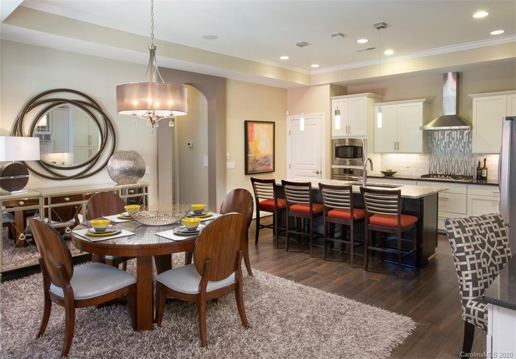 2018 New Style Way, Unit 5 Tega Cay, SC 29708 - Photo 5 of 36 a dining room with wooden floor a chandelier a wooden table and chairs