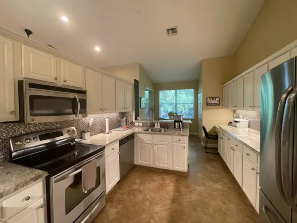 a kitchen with a sink stove top oven and refrigerator