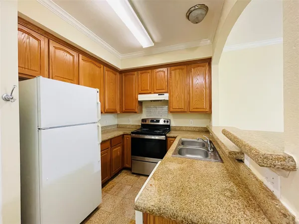 a kitchen with a refrigerator a stove top oven a sink and dishwasher with wooden floor