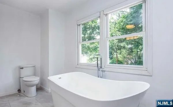 a white bath tub sitting next to a toilet