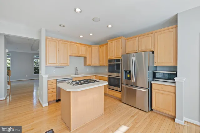 a large kitchen with granite countertop a stove a sink and a microwave