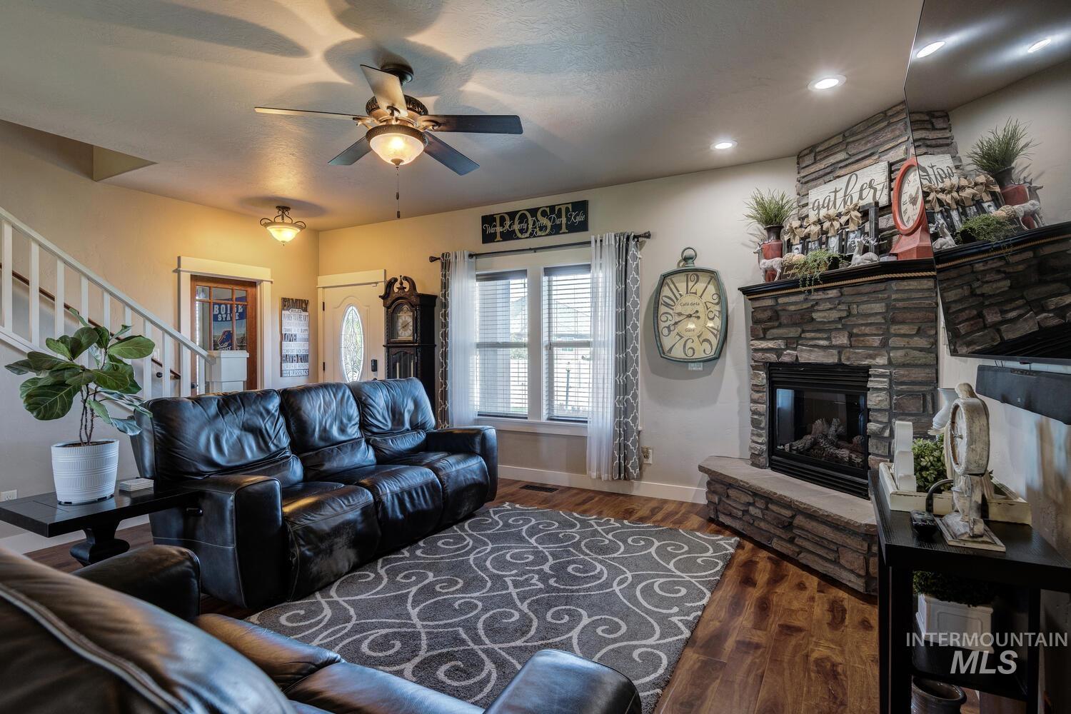 22757 Rosicky Way Caldwell, ID 83607 - Photo 10 of 50 Living area featuring stairway, a fireplace, dark wood-type flooring, a ceiling fan, and recessed lighting