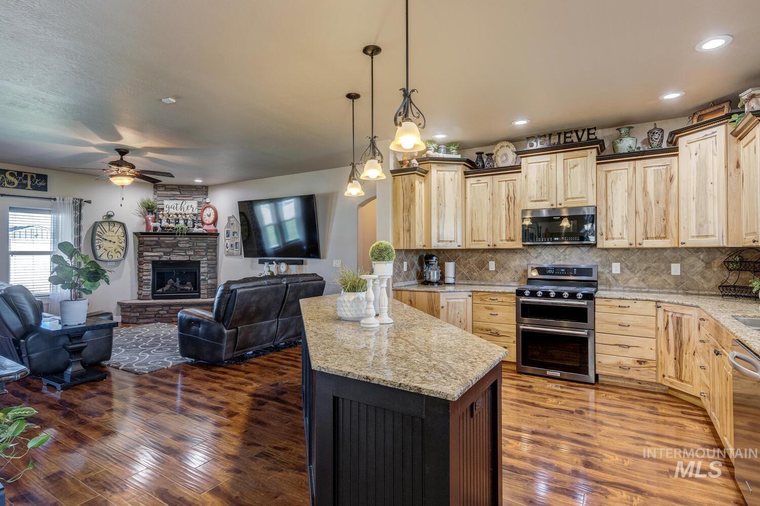 22757 Rosicky Way Caldwell, ID 83607 - Photo 50 of 50 Kitchen featuring light brown cabinets, stainless steel appliances, tasteful backsplash, hanging light fixtures, and open floor plan