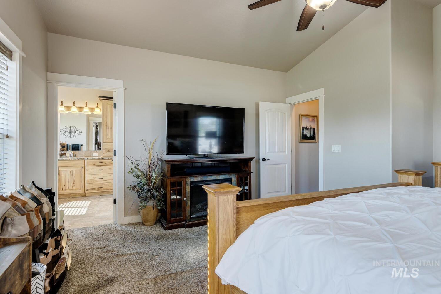 22757 Rosicky Way Caldwell, ID 83607 - Photo 20 of 50 Bedroom featuring light colored carpet, a ceiling fan, lofted ceiling, and connected bathroom