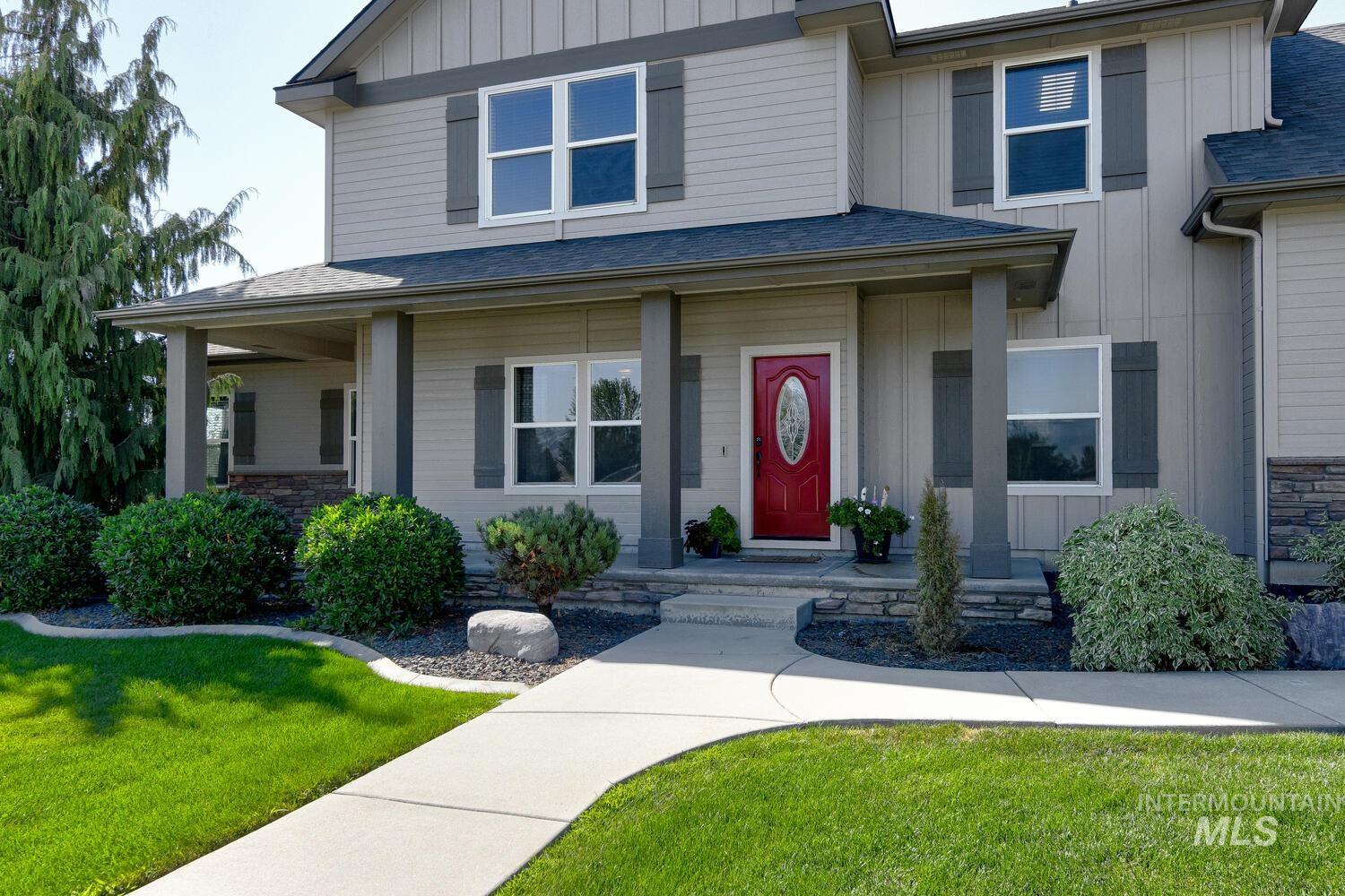 22757 Rosicky Way Caldwell, ID 83607 - Photo 5 of 50 Property entrance featuring board and batten siding, a lawn, stone siding, and a shingled roof