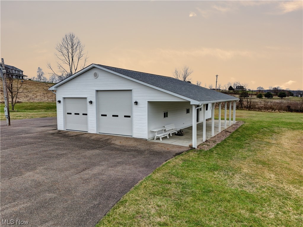 4301 Murray Road Dover, OH 44622 - Photo 43 of 49 Garage at dusk featuring a lawn