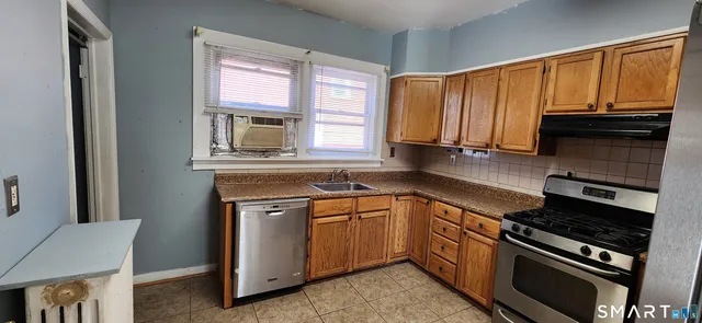 a kitchen view with a sink a window and a refrigerator