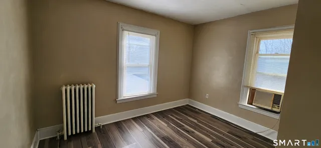 a view of a hallway with wooden floor and windows