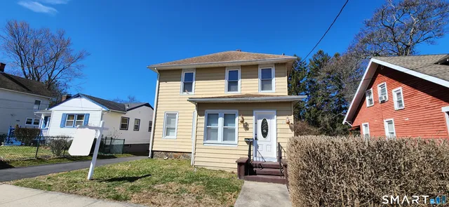 a view of a backyard with wooden fence and large trees