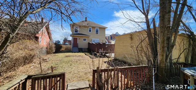a view of a house with wooden deck and furniture