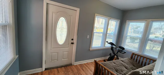 a view of a hallway with wooden floor and windows
