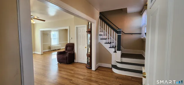 a view of entryway and hall with wooden floor