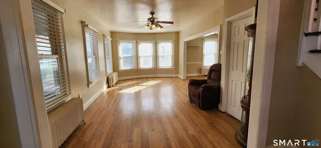 a view of hallway with wooden floor and furniture