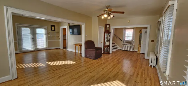 a view of a livingroom with furniture hardwood floor and a ceiling fan