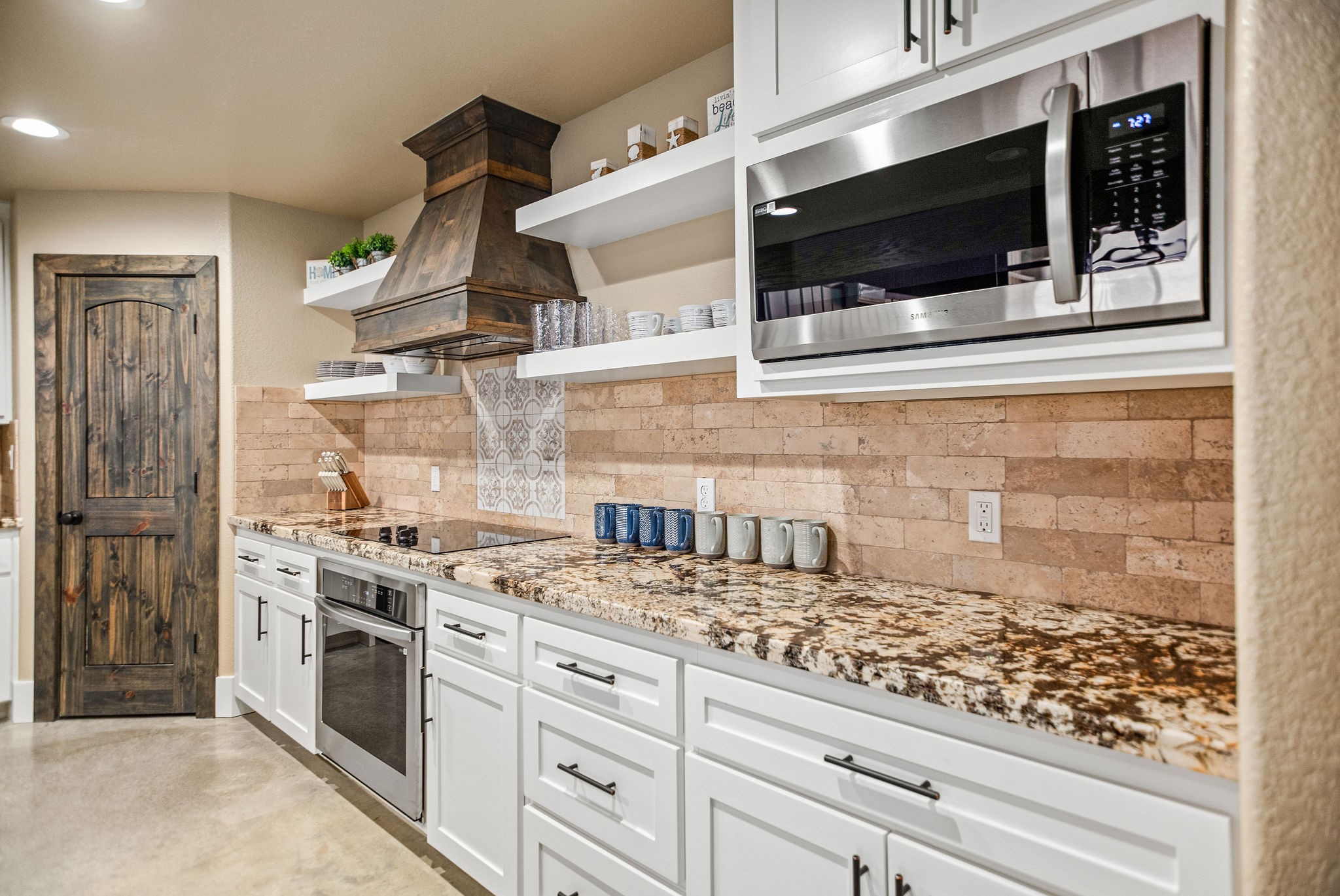 82 Circle Hook Port O'Connor, TX 77982 - Photo 13 of 32 a kitchen with stainless steel appliances granite countertop a stove and a microwave