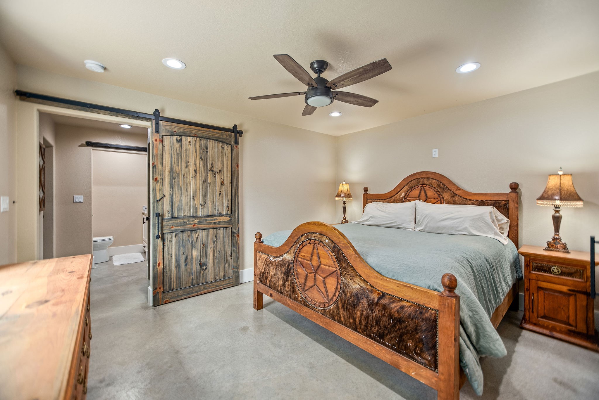 82 Circle Hook Port O'Connor, TX 77982 - Photo 19 of 32 a bedroom with a bed and a chandelier