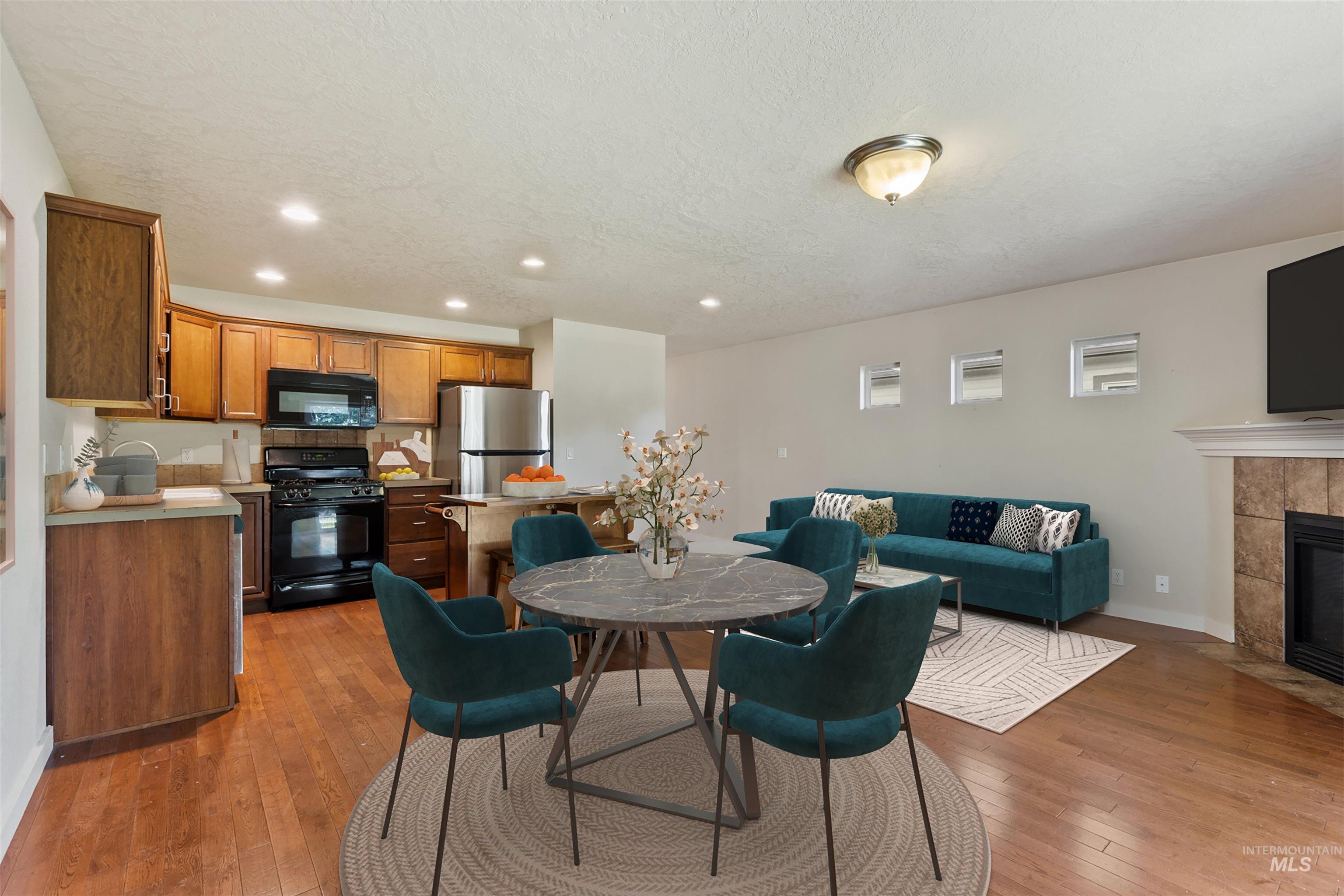 2209 South Amy Avenue Boise, ID 83706 - Photo 11 of 30 Dining area with recessed lighting, light wood-style floors, a tiled fireplace, and a textured ceiling