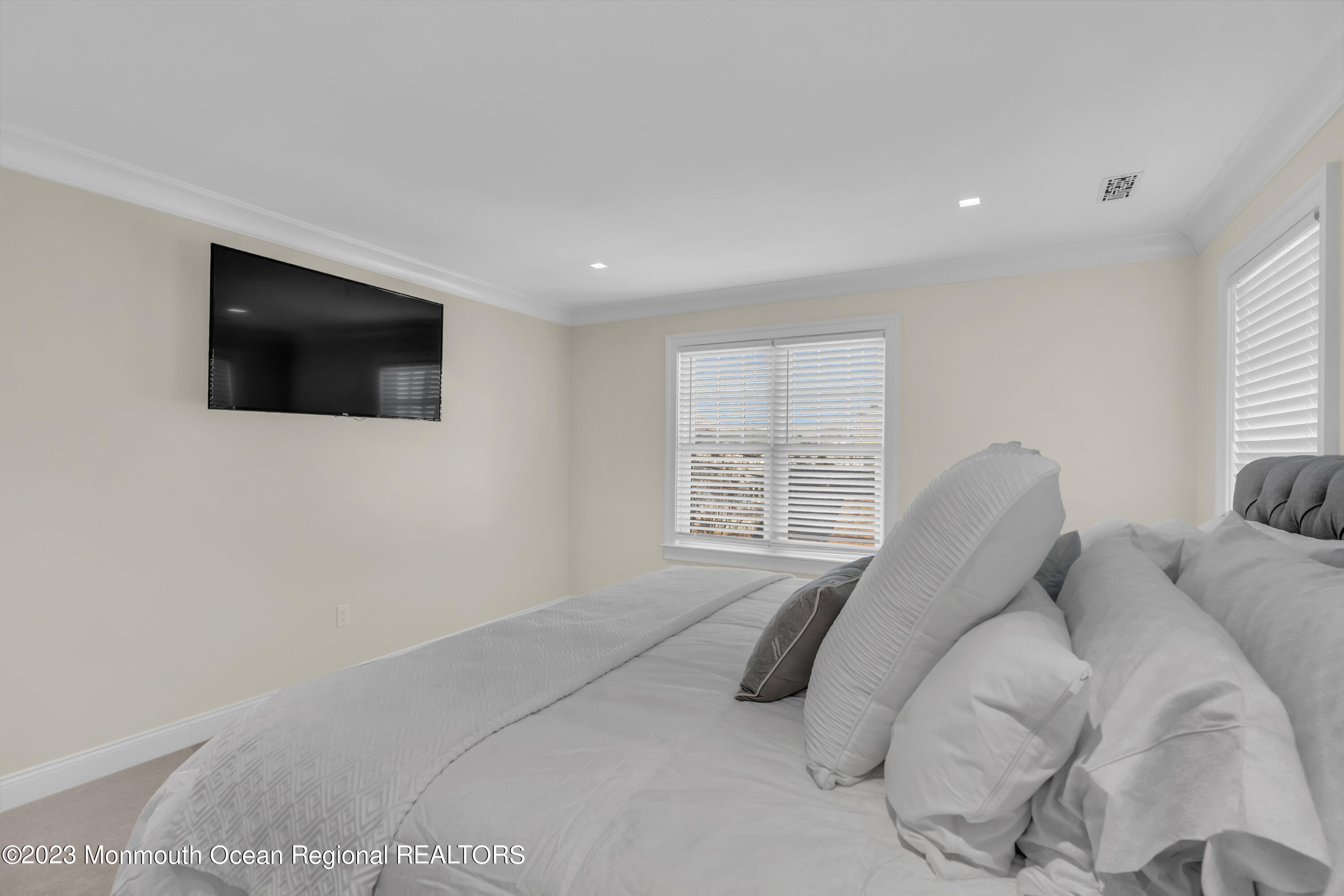 502 Brighton Avenue Spring Lake, NJ 07762 - Photo 40 of 78 a spacious bedroom with a bed a flat screen tv and windows