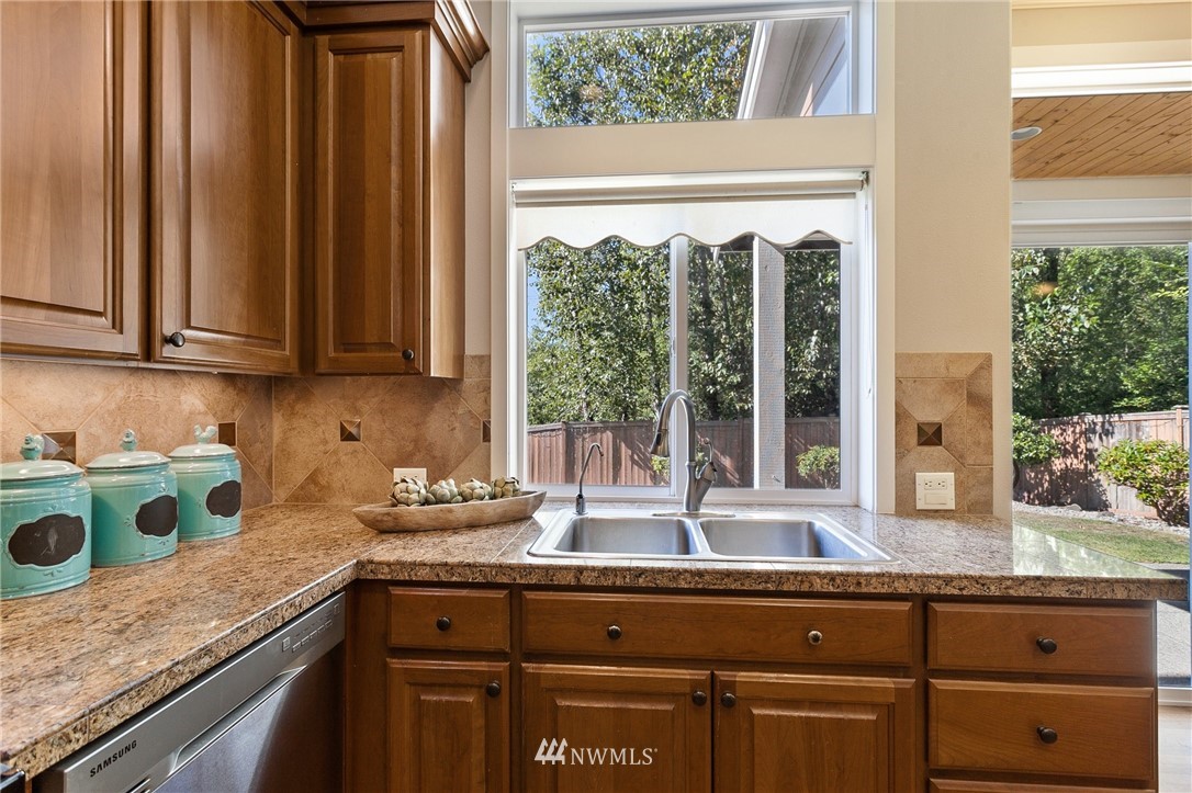 718 South 36th Place Renton, WA 98055 - Photo 11 of 40 a kitchen with granite countertop a sink and a window