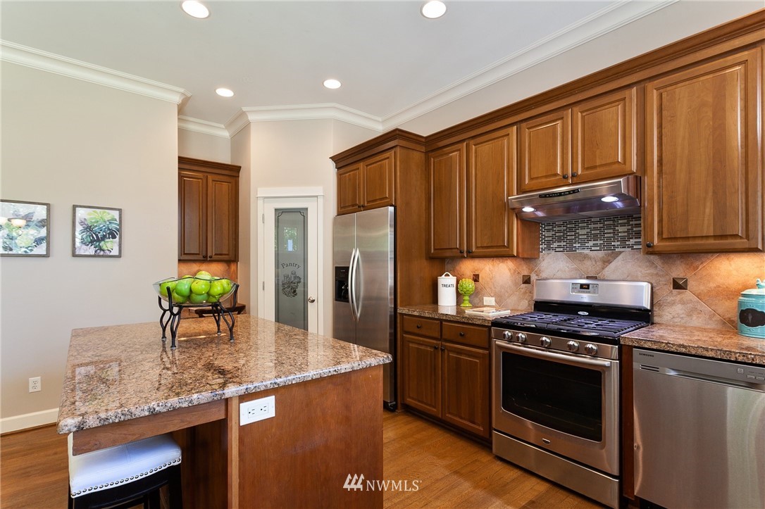 718 South 36th Place Renton, WA 98055 - Photo 12 of 40 a kitchen with granite countertop stainless steel appliances and wooden cabinets