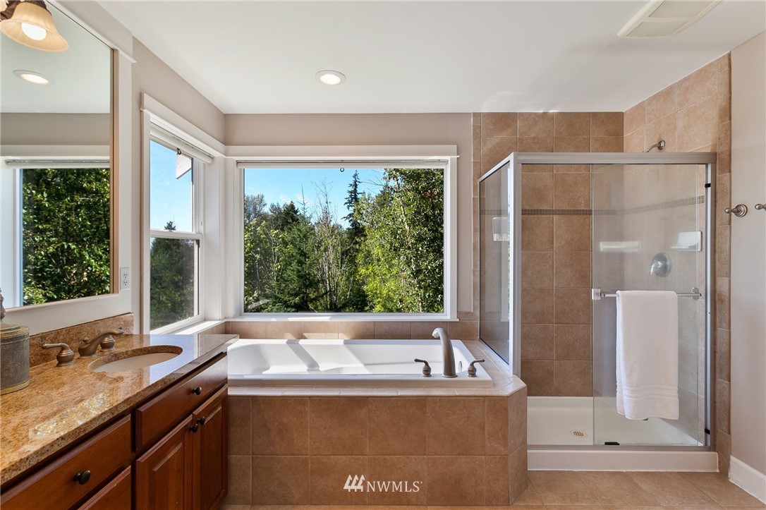 718 South 36th Place Renton, WA 98055 - Photo 23 of 40 a bathroom with a tub a sink and large windows