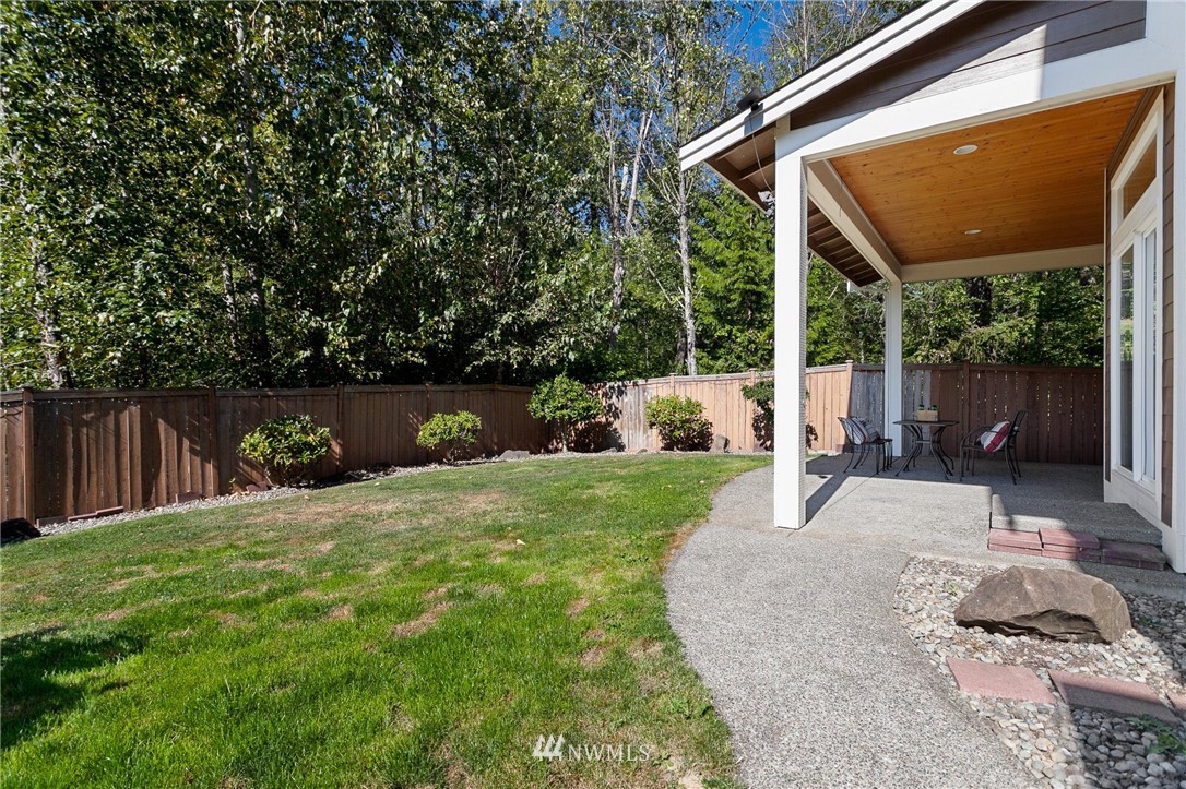 718 South 36th Place Renton, WA 98055 - Photo 37 of 40 a backyard of a house with a fountain plants and large tree