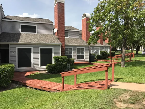 a view of a house with a yard porch and a large tree
